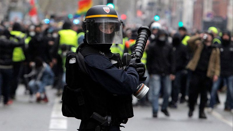 Un polic&iacute;a franc&eacute;s roc&iacute;a gas pimienta a un activista de los &lsquo;chalecos amarillos&rsquo; en silla de ruedas